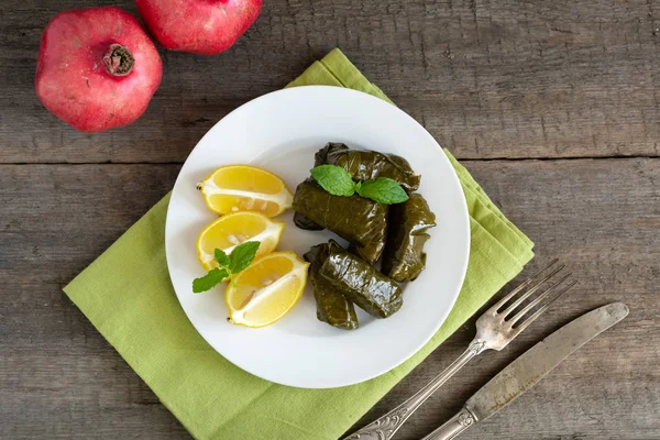 Hoja de uva llena de arroz servido con limón. Comida griega tradicional —  Fotos de Stock