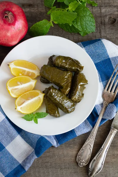 Hoja de uva llena de arroz servido con limón. Comida griega tradicional —  Fotos de Stock
