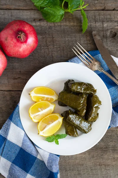 Hoja de uva llena de arroz servido con limón. Comida griega tradicional —  Fotos de Stock