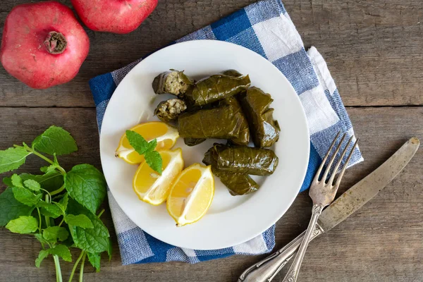 Hoja de uva llena de arroz servido con limón. Comida griega tradicional —  Fotos de Stock