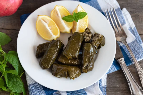 Hoja de uva llena de arroz servido con limón. Comida griega tradicional —  Fotos de Stock