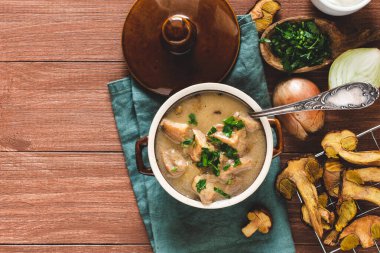 Ekşi kremalı ve maydanozlu mantar çorbası. Ahşap arka planda sonbahar yemekleri.