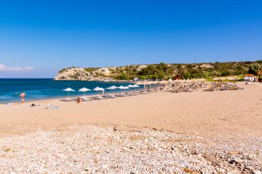 Rodos, Yunanistan - 12 Mayıs 2018: Sandy Kolymbia plajı güneş pansiyonları ve şemsiyeli. Rodos Adası, Yunanistan