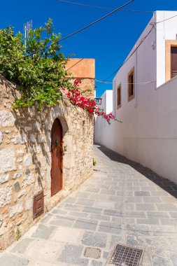 Lindos köyünde yaz çiçekleri olan güzel bir Yunan caddesi. Rhodes Adası. Yunanistan.