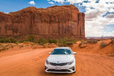 Utah / Arizona, ABD: 6 Nisan 2019: Kia Optima arabası ve Anıt Vadisi 'nin ünlü kırmızı kayası. Navajo Kabile Parkı manzarası
