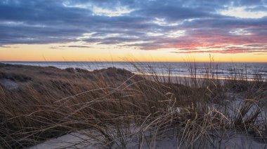 Lokken yakınlarındaki Gronhoj Strand plajda sakin ve renkli gün batımı, Danimarka