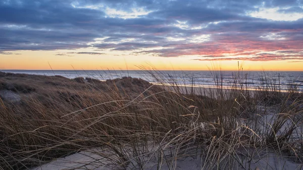 Lokken yakınlarındaki Gronhoj Strand plajda sakin ve renkli gün batımı, Danimarka