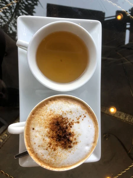 Bir fincan sıcak cappuccino ve bir fincan çay