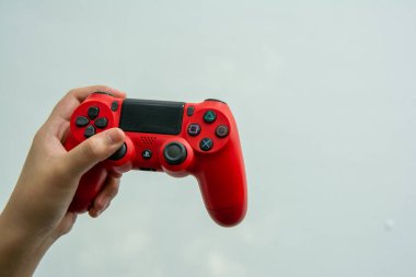 BANGKOK, THAILAND, 14 EYLÜL 2019: Büyük bir oyun kampı Sony 'nin 4 numaralı playstation' ından kırmızı bir joystick tutan bir kız
