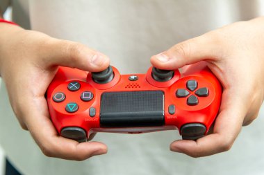 BANGKOK, THAILAND, 14 EYLÜL 2019: Büyük bir oyun kampı Sony 'nin 4 numaralı playstation' ından kırmızı bir joystick tutan bir kız