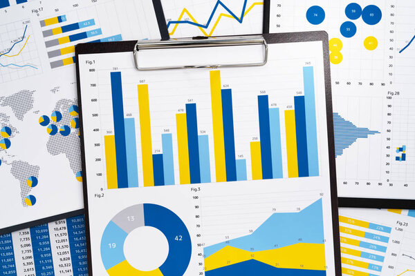 Pile of marketing reports. Many charts and graphs. Gathering and analyzing statistical data