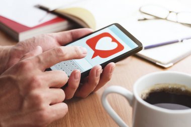 Aşk ve sosyal medya kavramı. Akıllı telefon ekranında kalp işareti simgesi. 