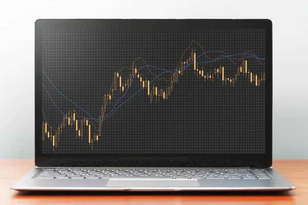 笔记本电脑屏幕上的股票市场烛台图. 图库图片