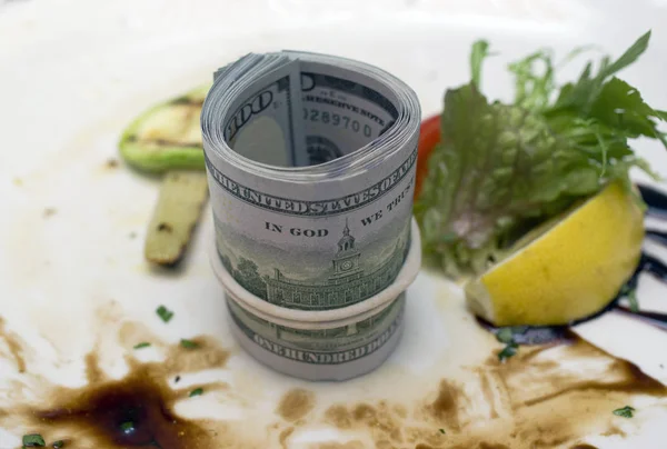 A bundle of US dollars on a dirty food plate