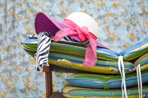 Ladies wide brimmed hats laid on the top of colorful mattresses