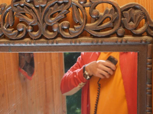 Vintage mirror and a reflection of a man standing with electric shaver