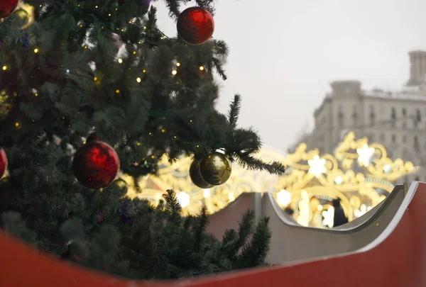 Decorated Christmas tree in the foreground and city landscape in the blurred background