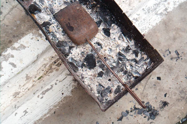 Barbecue trolley, scoop, coal and ash left inside, overhead shot
