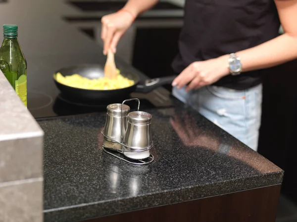 Salt and pepper shakers and woman cooking — Stock Photo, Image