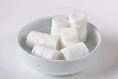 bir yığın sıkıştırılmış sikke doku ve ıslak, beyaz bir arka plan üzerinde küçük bir çanak sonra genişletilmiş doku