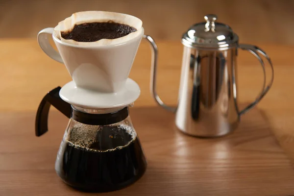 ceramic hand drip coffee brewer (dripper) and drip ground coffee on a glass server with stainless drip pot