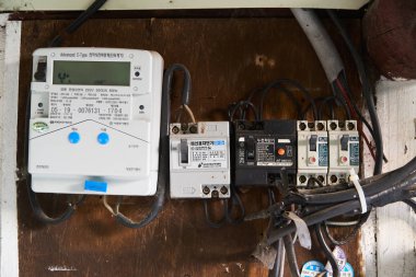 Inje-gun, Kore-10 Mayıs 2018: eski teller, devre kesici ve Kore eski evin ahşap bir tahta üzerinde yüklü dijital akıllı elektrik ölçerler.
