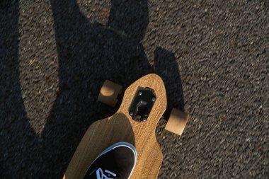 Longboard arka plan asfalt yol üzerinde çalışan yan burun