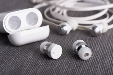 Kablosuz kablosuz bluetooth kulaklıkları bir arka plan üzerinde ücretli durumda olan kablo kulaklık