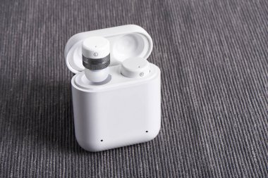 Kablosuz kablosuz bluetooth kulaklıkları ile kumaş arka plan üzerinde ücretli hal