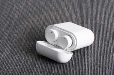 Kablosuz kablosuz bluetooth kulaklıkları ile kumaş arka plan üzerinde ücretli hal