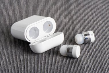 Kablosuz kablosuz bluetooth kulaklıkları ile kumaş arka plan üzerinde ücretli hal