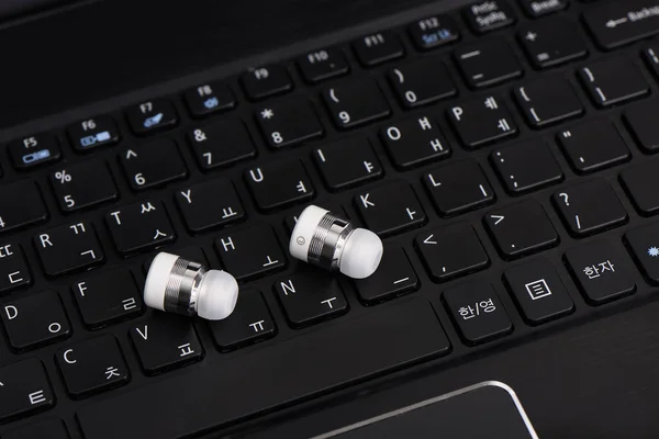 Dizüstü Bilgisayarın Klavyesinde Kablosuz Kablosuz Bluetooth Kulaklıkları — Stok fotoğraf