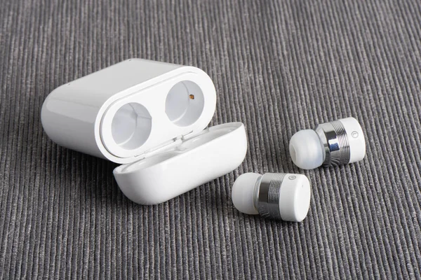 Kablosuz kablosuz bluetooth kulaklıkları ile kumaş arka plan üzerinde ücretli hal