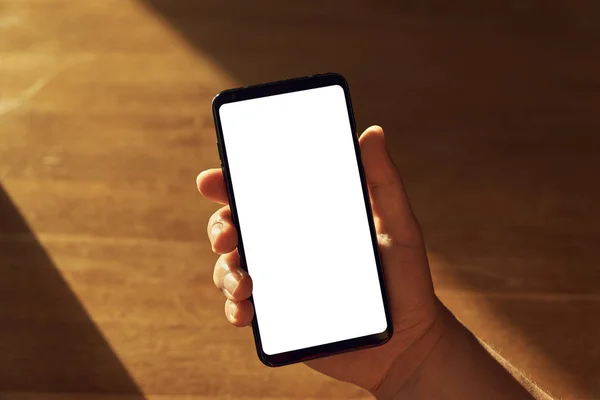 Een Smartphone Met Leeg Scherm Houdt Een Hand Tegen Een — Stockfoto