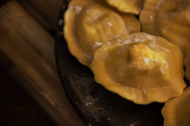 stuffed pasta with salmon and cheese on a black stone plate