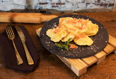 siyah taş tabakta somon ile doldurulmuş makarna