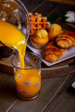 Kahvaltıda portakal suyu servisi ya da arka planda hamur işleri.