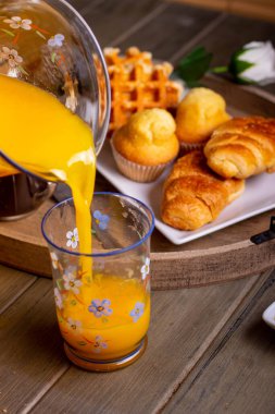 Kahvaltıda portakal suyu servisi ya da arka planda hamur işleri.