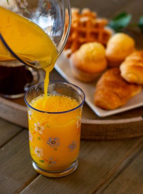 Kahvaltıda portakal suyu servisi ya da arka planda hamur işleri.