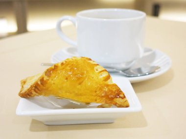 Lezzetli hamur işiyle birlikte bir fincan kahveyi yakın.