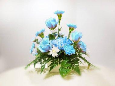 Bahar çiçekleri ve beyaz arka planda yeşil yapraklar.