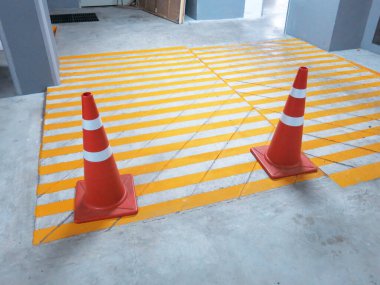 traffic warning cones in row to separate route in parking area.