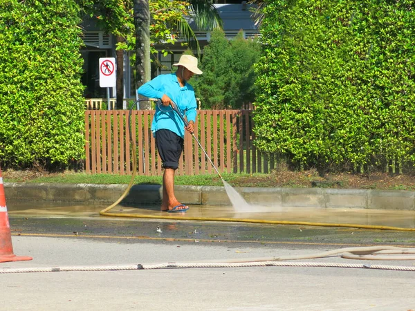 Person Holding Water Hose Cleaning City Street — Stock Fotó