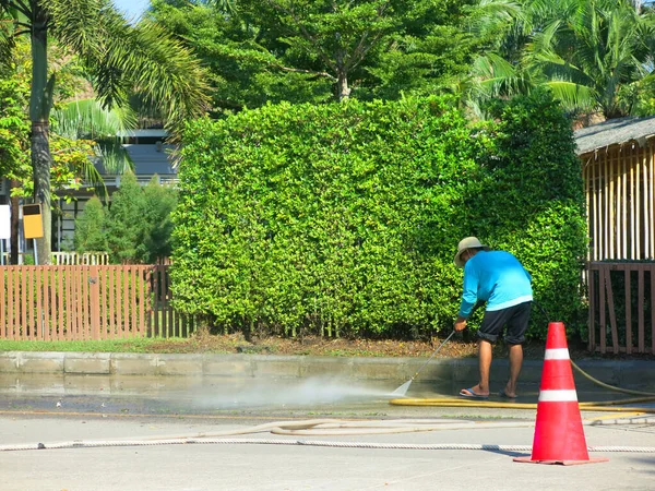 Person Holding Water Hose Cleaning City Street — Zdjęcie stockowe