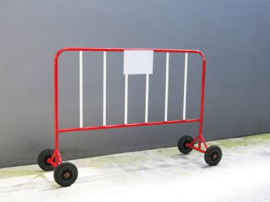 Metal moving fence on concrete wall background.