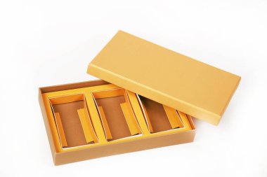 Beyaz arkaplanda izole edilmiş altın ambalaj kağıdıyla kahverengi kutunun yakın plan görüntüsü