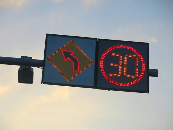 Road sign and traffic lighting on the road.