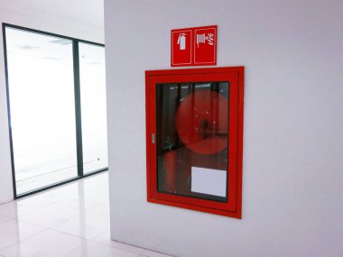 Fire safety equipment in the red box on wall
