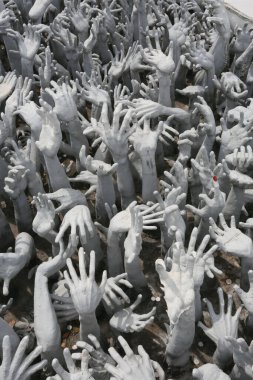 grey hands sculptures and coins