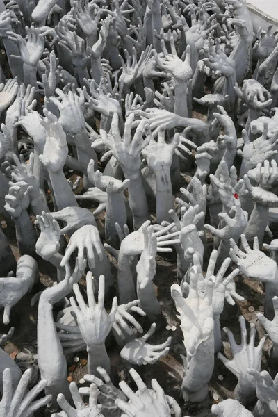 grey hands sculptures and coins